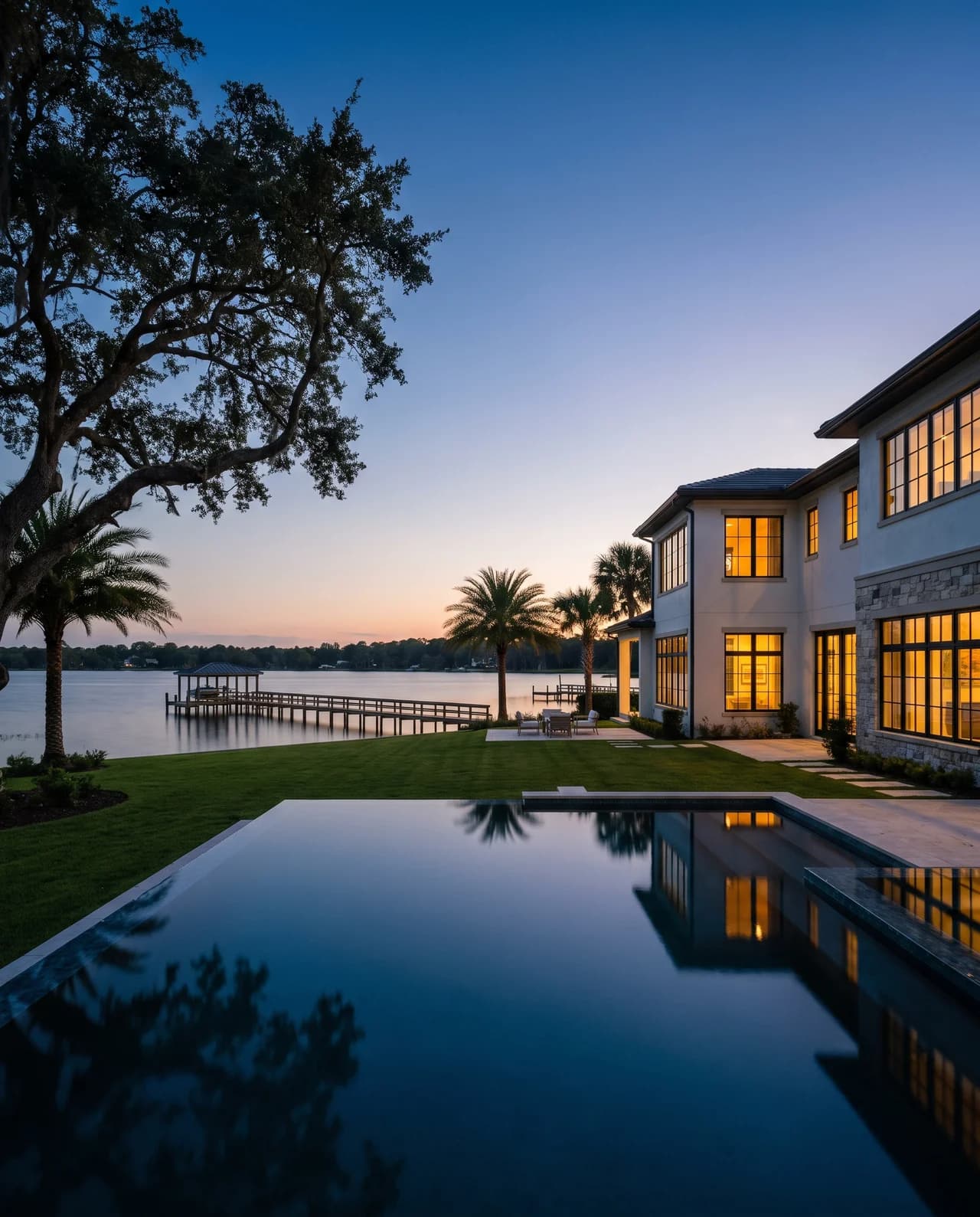 Lakefront estate at dusk in Windermere, the pool holding the last of the sky